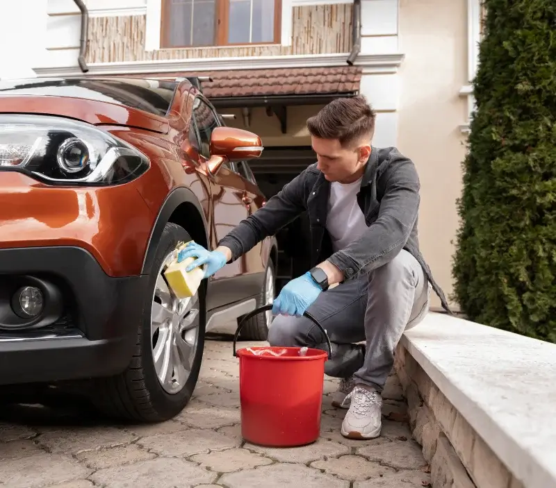 Lavage auto à domicile Génis : professionnel intervenant sur un véhicule